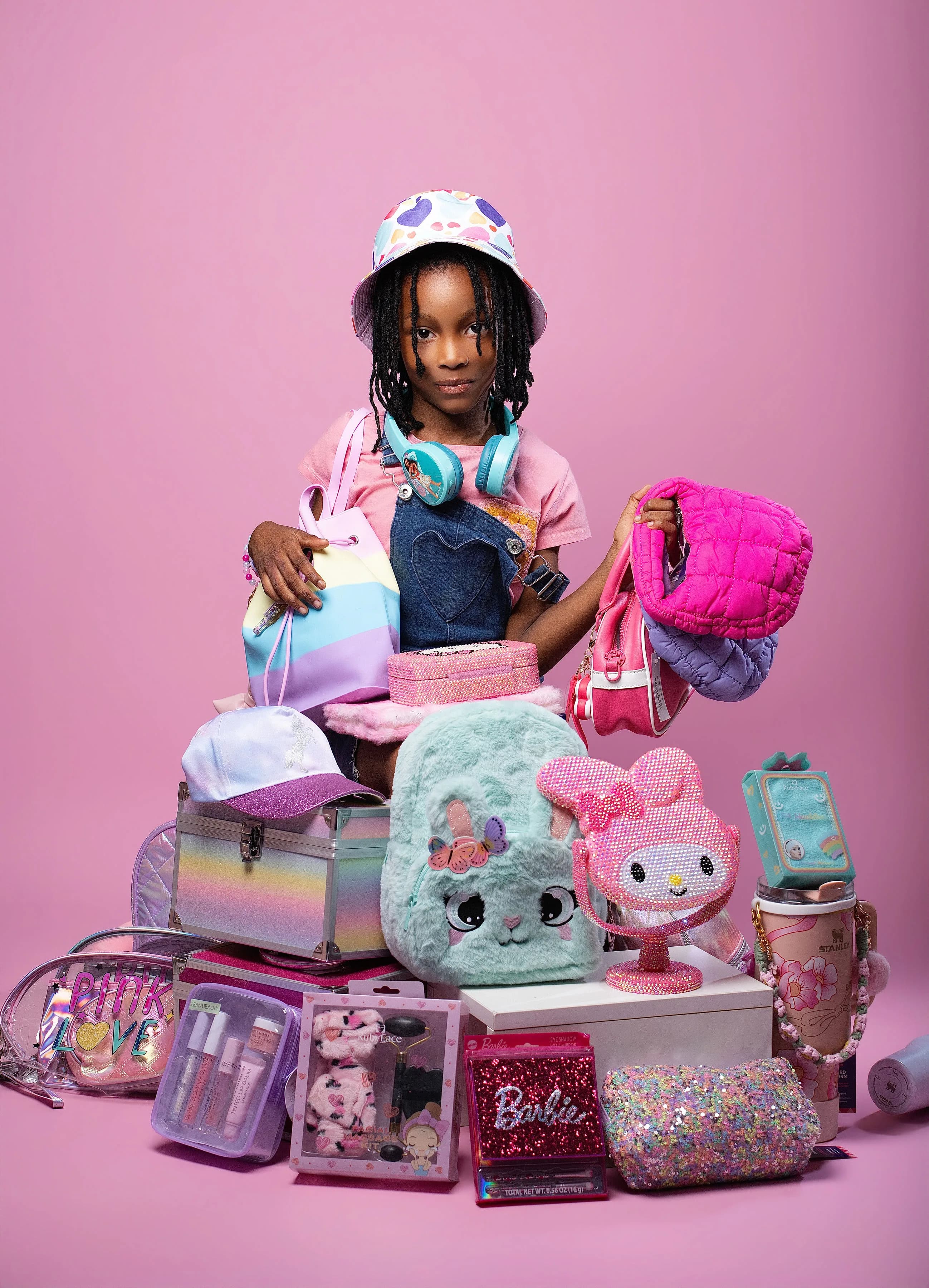 Child styled with colorful bags, caps, and accessories